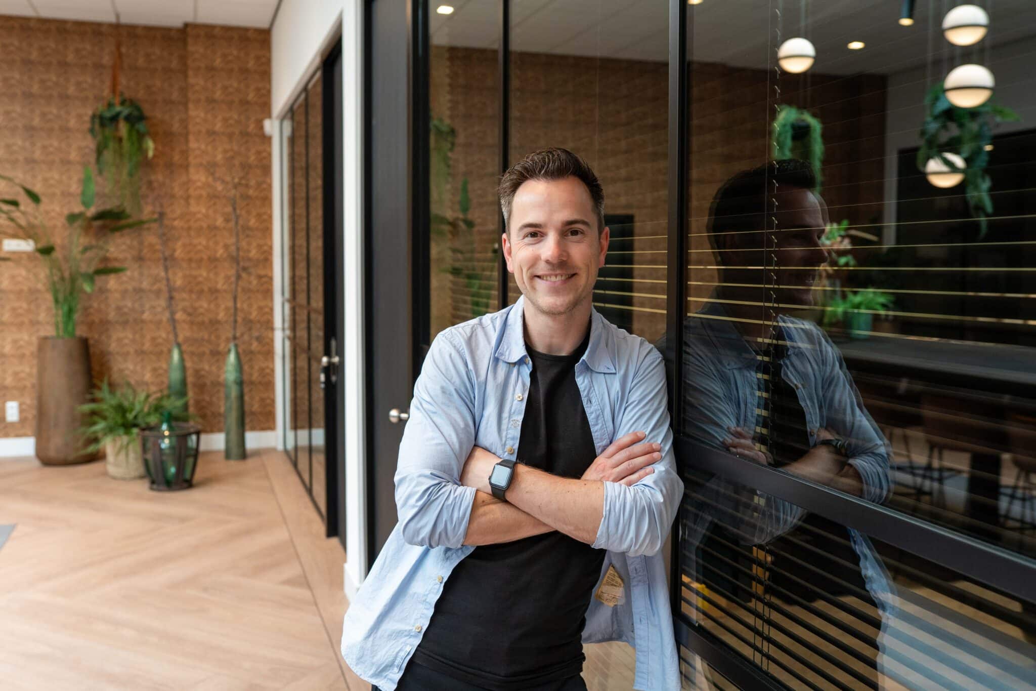 Maurice bij de glazen wand in het VIND-kantoor